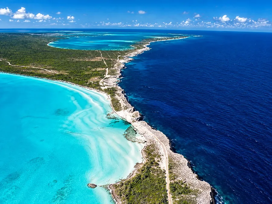 The narrow strip of Eleuthera at the Glass Window from the air, turquoise shallows on one side and the deep blue Atlantic on the other