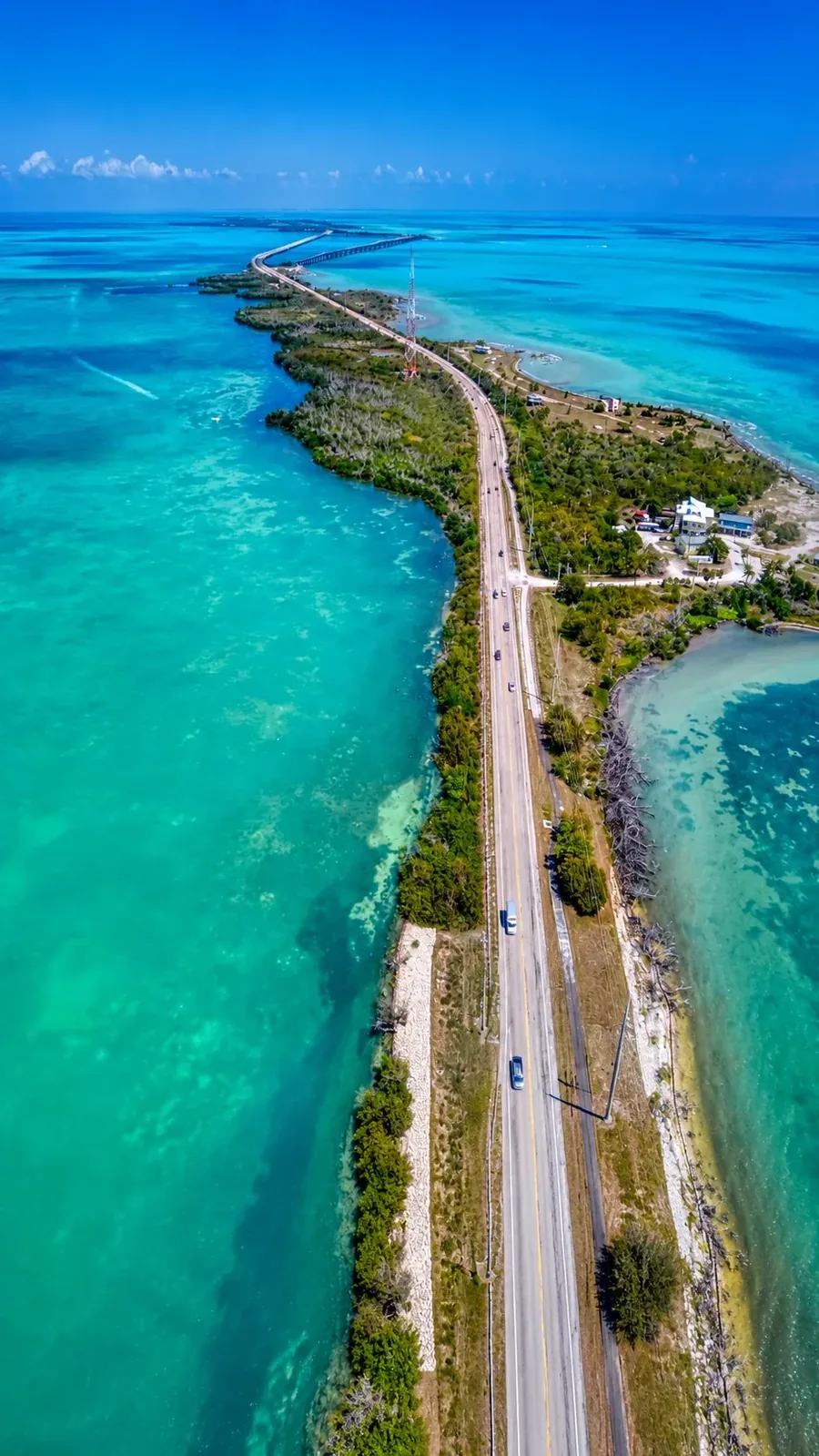 The Overseas Highway crossing the Florida Keys from the air, turquoise flats on both sides and the next bridge ahead