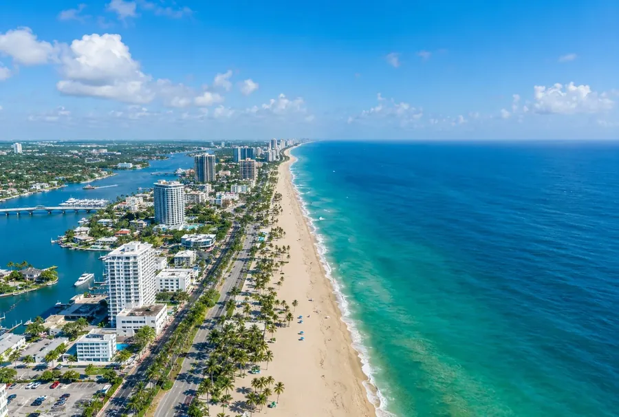 The Fort Lauderdale beachfront from the air, the palm lined coast road between the open ocean and the yacht berths on the Intracoastal