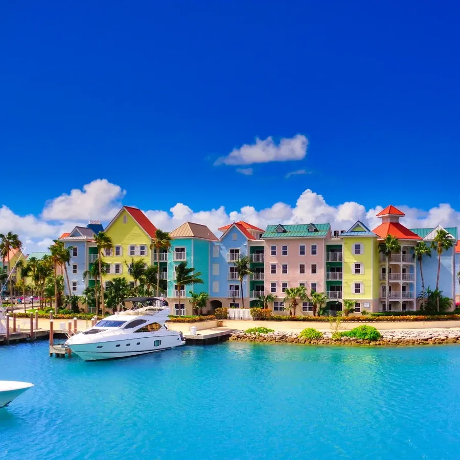 The pastel harbour front at Nassau with a motor yacht tied up on turquoise water