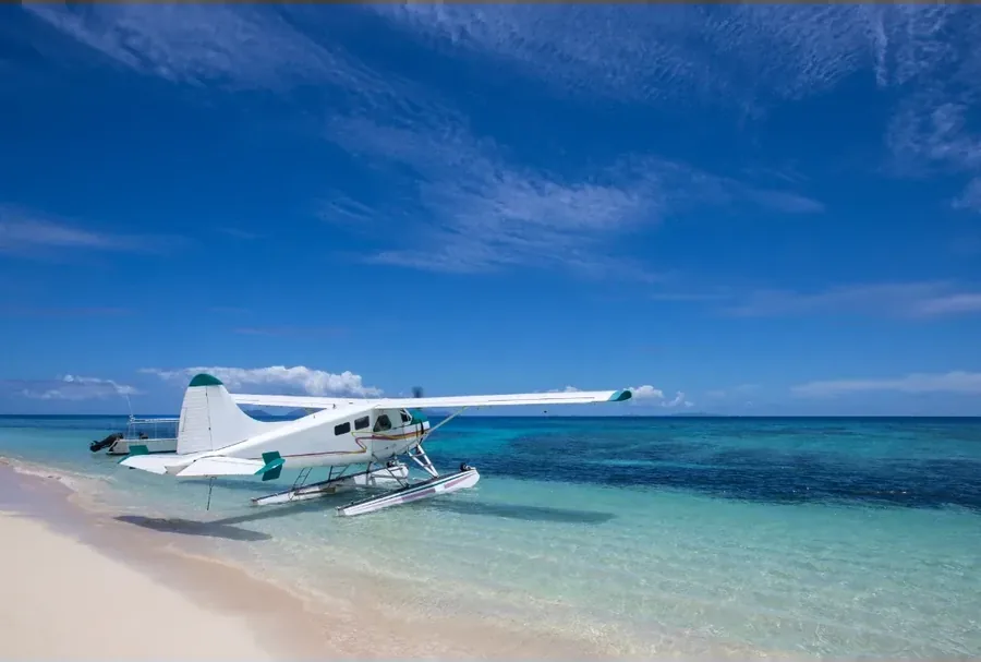 A seaplane on floats down on open water, with no runway or terminal anywhere in sight