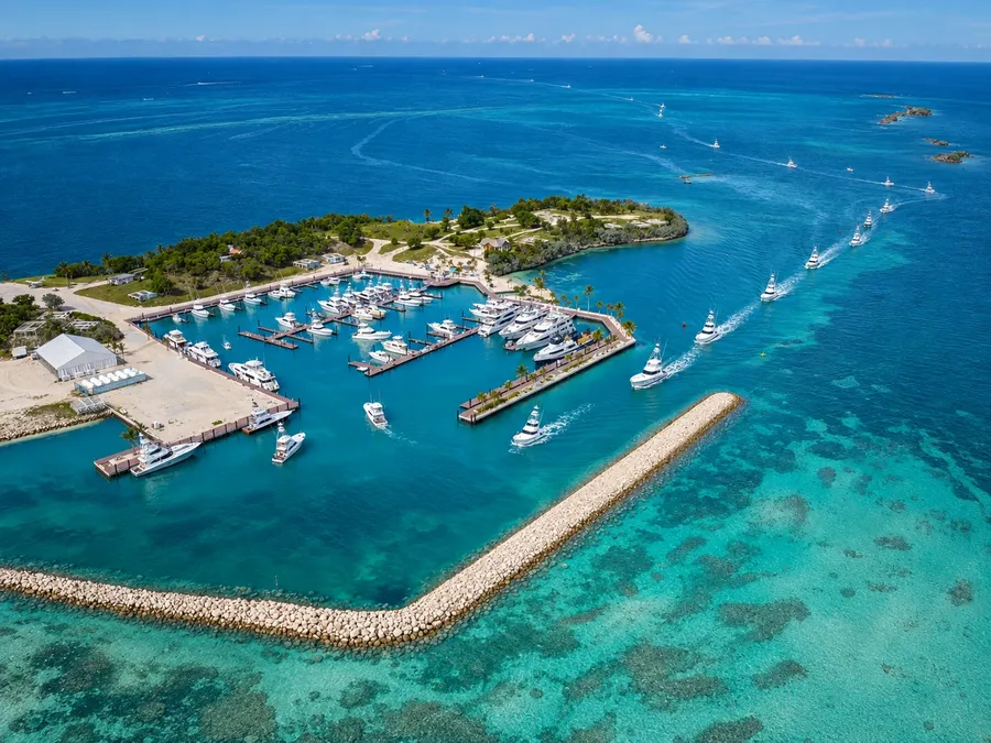 The marina at Walkers Cay from the air, sportfishing boats heading out past the breakwater into deep blue water